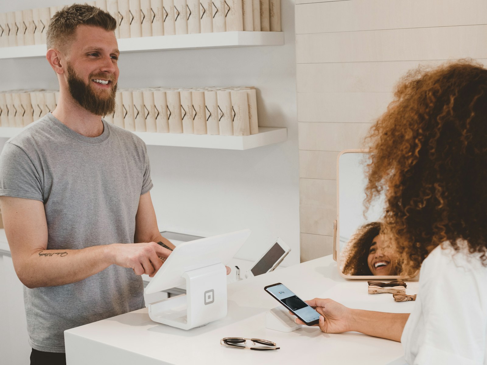 A store owner processing a customer's payment at checkout