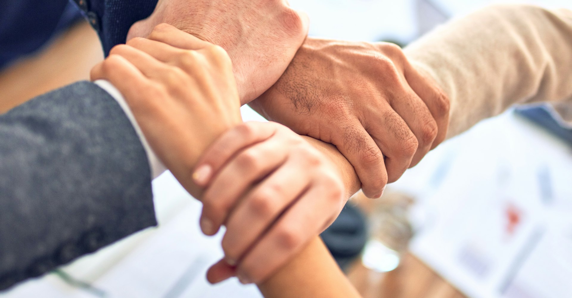 Team members joining hands in support of a shared community